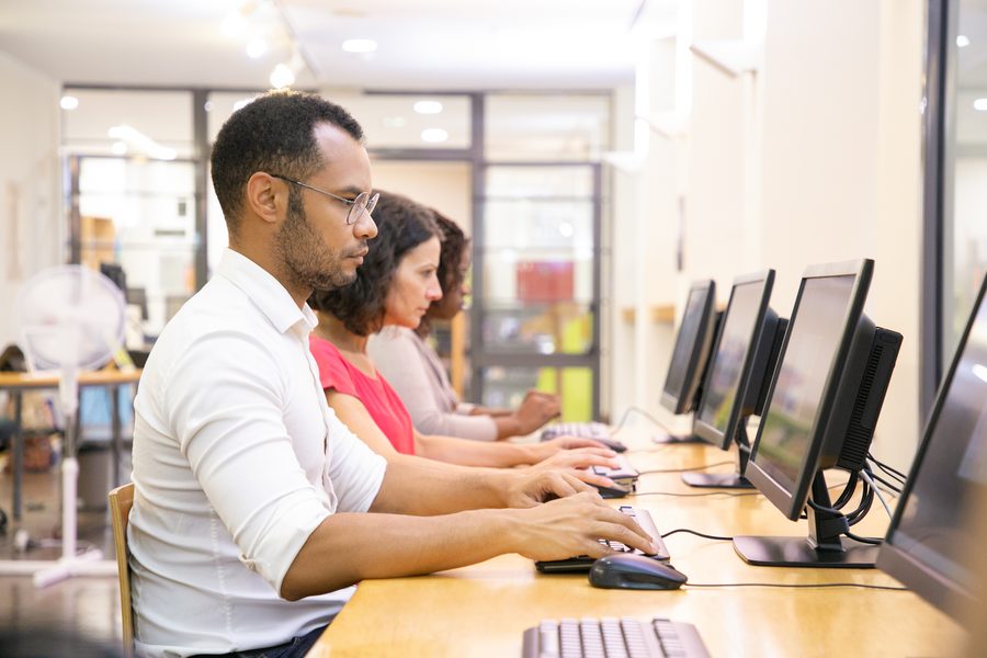 Candidates seated at computer workstations during an examination